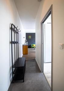 un corridoio con una panchina nera in una stanza di Le Loft Horloger avec parking a Besançon