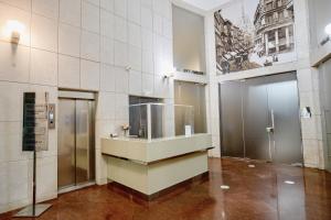 eine Lobby mit einem Waschbecken und zwei Aufzügen in einem Gebäude in der Unterkunft Aiello Hotels - Duomo in Mailand
