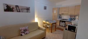 uma sala de estar com um sofá e uma cozinha em La Casa di Alberto em Camerino