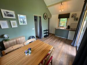 a dining room with a wooden table and a kitchen at Trekkershut - 4 personen in Beilen