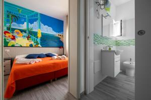 a bedroom with an orange bed with a painting on the wall at B&B La Terrazza Sul Porto in San Foca