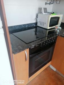 a kitchen with a microwave and a stove at Riells playa in L'Escala