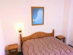 um quarto com uma cama com uma fotografia na parede em Chalet La Joue du Loup, 3 pièces, 7 personnes - FR-1-504-54 em Le Dévoluy