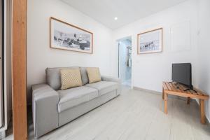a living room with a couch and a tv at Vila Farol in Nazaré