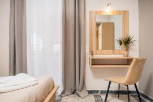 a bedroom with a bed and a mirror and a chair at Asya Sea View Apartment in Plános