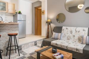 a living room with a couch and a kitchen at Asya Sea View Apartment in Planos