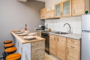 a kitchen with wooden cabinets and a counter with stools at Asya Sea View Apartment in Planos