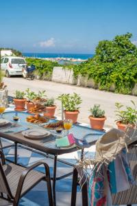 a table with plates of food on it next to the ocean at Asya Sea View Apartment in Planos +30 photos