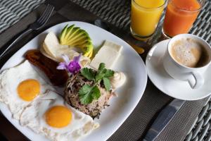 a plate of breakfast food with eggs and a cup of coffee at Tifakara Boutique Hotel & Birding Oasis in Fortuna
