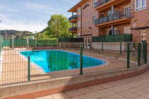 una piscina detrás de una valla junto a un edificio en Sabea - Baskey Rentals, en Iraeta