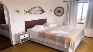 a bedroom with a bed with a colorful blanket at Pousada do Sol in Lagoinha