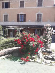 un grand bâtiment avec des fleurs rouges devant lui dans l'établissement villart, à Carbonara Scrivia