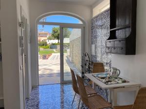 a dining room with a table and chairs and an open door at Villa Raffaella in Capri