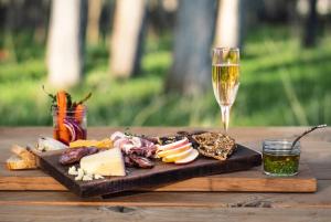a wooden table with a plate of cheese and a glass of wine at Bodhi Farms in Bozeman