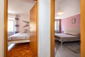 a bedroom with two beds and a mirror at Apartman Best in Novigrad Dalmatia