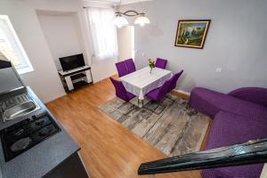 a living room with a table and purple chairs at Apartman Best in Novigrad Dalmatia