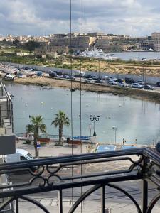 a view of a large body of water from a balcony at Sir William Strand in Il-Gżira