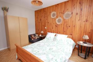 a bedroom with a bed with a wooden wall at Coquet appartement Type 2 de 56 m² en centre ville in Briançon