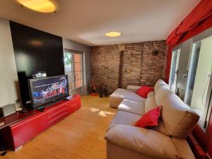 a living room with a couch and a flat screen tv at Duplex Revellín Frida Home AIRE ac in Logroño