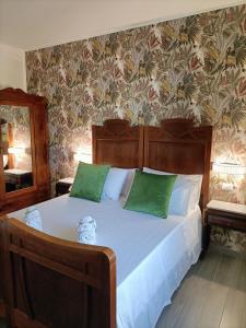 ein Schlafzimmer mit einem großen Bett mit grünen Kissen in der Unterkunft La Ricarda Dimora di Campagna in Paestum