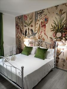 ein Schlafzimmer mit einem weißen Bett und grünen Kissen in der Unterkunft La Ricarda Dimora di Campagna in Paestum