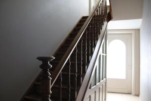 a staircase with black railings in a house at Maison Remy in Ieper