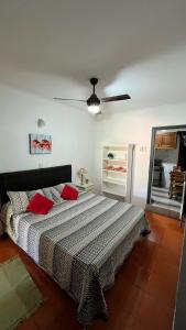 una camera da letto con un letto con cuscini rossi di Patry's Cottage a Puerto Iguazú