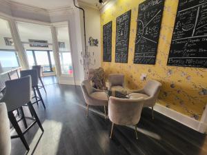 un restaurant avec des chaises, une table et un tableau noir dans l'établissement The Bromley, à Blackpool