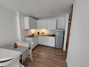 a kitchen with white cabinets and a table and a table and a table at Preilos39 in Preila