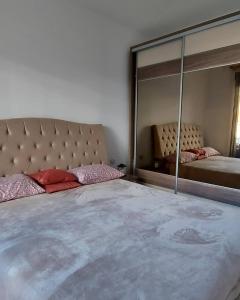 1 dormitorio con 1 cama grande y espejo grande en Impressive apartment en Trebinje