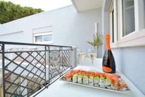 een bord sushi en wijnglazen op een balkon bij Prime Blue Suite - Bilocale in Riccione