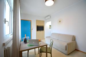 een woonkamer met een bank en een tafel met een laptop bij Prime Blue Suite - Bilocale in Riccione