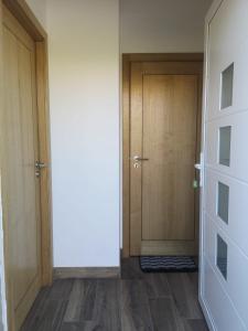 korytarz z dwoma drewnianymi drzwiami i drewnianą podłogą w obiekcie 5 Cinco w mieście Chaves