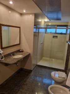 uma casa de banho com um chuveiro, um lavatório e um WC. em Royalty Copacabana Hotel no Rio de Janeiro