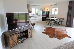 een woonkamer met een flatscreen-tv en een tafel bij Kuh Heimat - Bergblick - Terrasse in Buchenberg