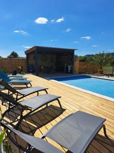 Un grupo de sillas en una terraza junto a una piscina. en Le Domaine Vesque, en Saint-Pierre-de-Clairac