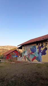 a building with a mural on the side of it at Pousada Barriga da Lua in Serra do Cipo