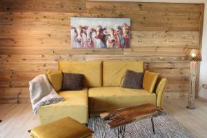 a living room with a yellow couch and a painting at Kuh Heimat - Bergblick - Terrasse in Buchenberg