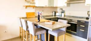 Una cocina con una mesa con sillas y una encimera. en Casa Banana Sunset, en Santa Cruz de Tenerife