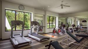 un gimnasio con varias máquinas de correr y un espejo en Melia Cozumel All Inclusive en Cozumel