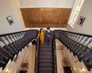 Um homem e uma mulher a descer as escadas. em Lansbury Heritage Hotel em Londres