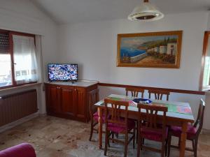 een eetkamer met een tafel en stoelen en een televisie bij Casa vacanza in colline abruzzesi in Bellante