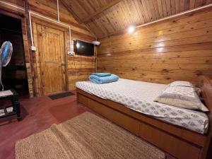 a bedroom with a bed in a wooden cabin at The Memory Lane in Siolim