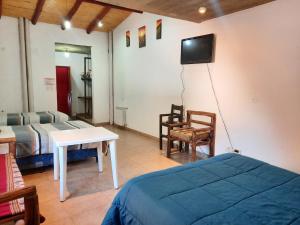 a bedroom with a bed and a tv on the wall at La Posada de la Calandria in Purmamarca