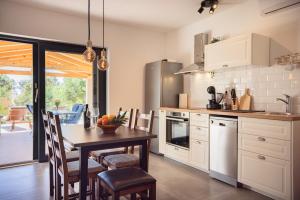 a kitchen with a table and a dining room at Old Road in Vir