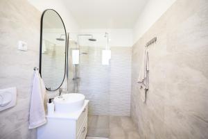a white bathroom with a sink and a mirror at Old Road in Vir +29 photos