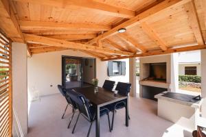 a dining room with a wooden ceiling and a table and chairs at Old Road in Vir