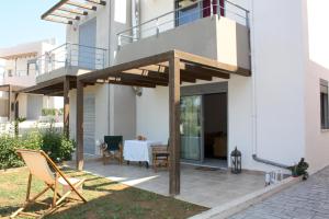 a patio with a wooden pergola on a house at ATHINA-Georgia in Kamárai