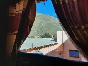 uma vista para uma montanha a partir de uma janela em La Posada de la Calandria em Purmamarca