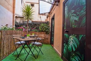 een patio met een tafel en stoelen en een hek bij B&B Al Centro in Agrigento